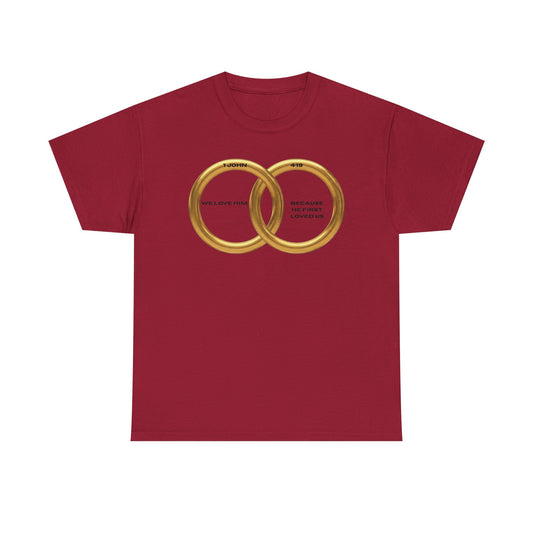 Front Christian Valentine t-shirt featuring two interlocking gold rings with the Bible verse We love Him because He first loved us from 1 John 4:19, minimalist faith-based design
